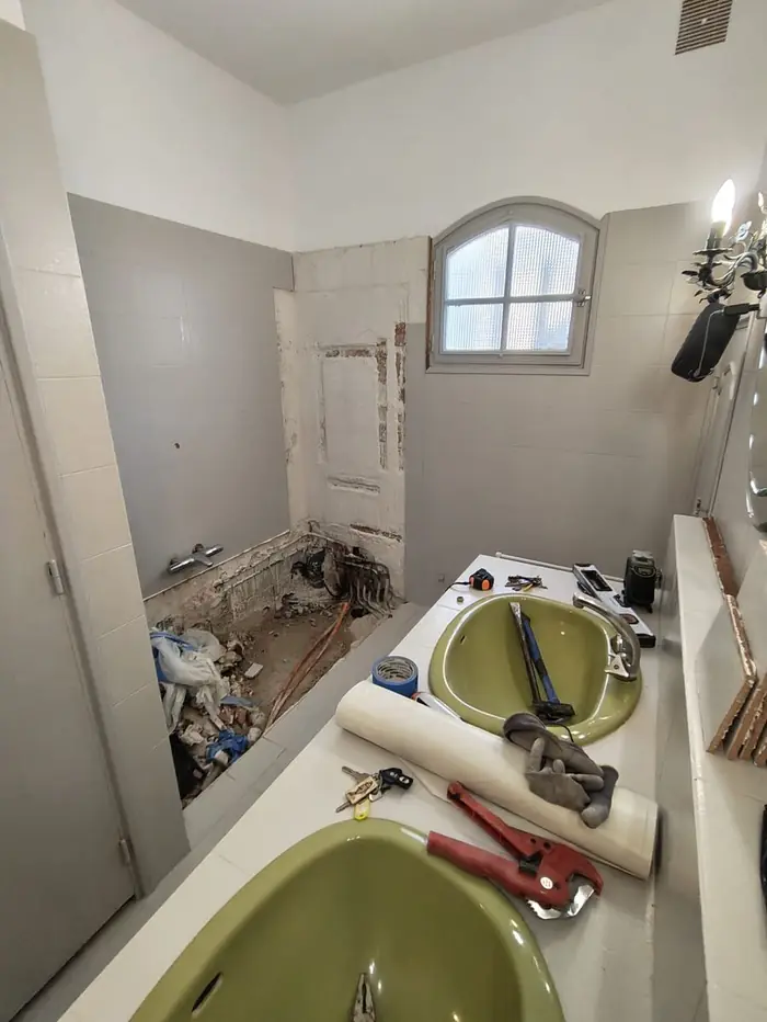 Avant travaux : ancienne salle de bain avec lavabo vert, en cours de démolition