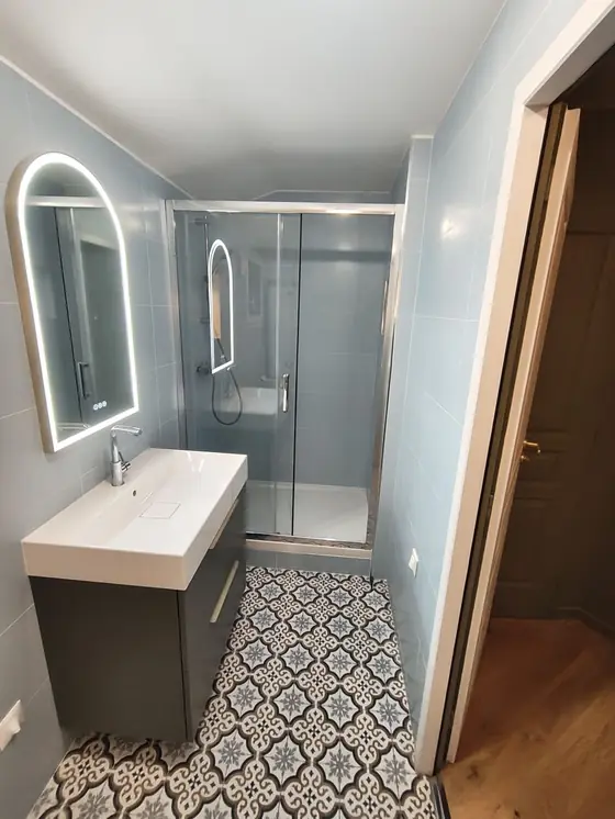 Salle de bain aménagée : douche vitrée et meuble vasque