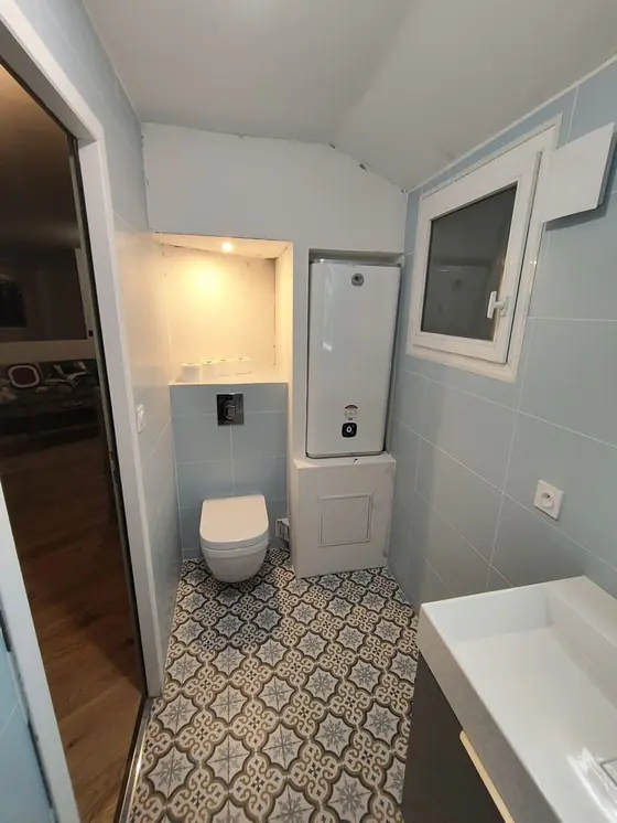 Installation électrique et chauffe-eau dans une salle de bain rénovée