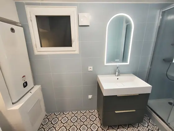 Salle de bain rénovée : meuble vasque, miroir LED et carreaux de ciment au sol